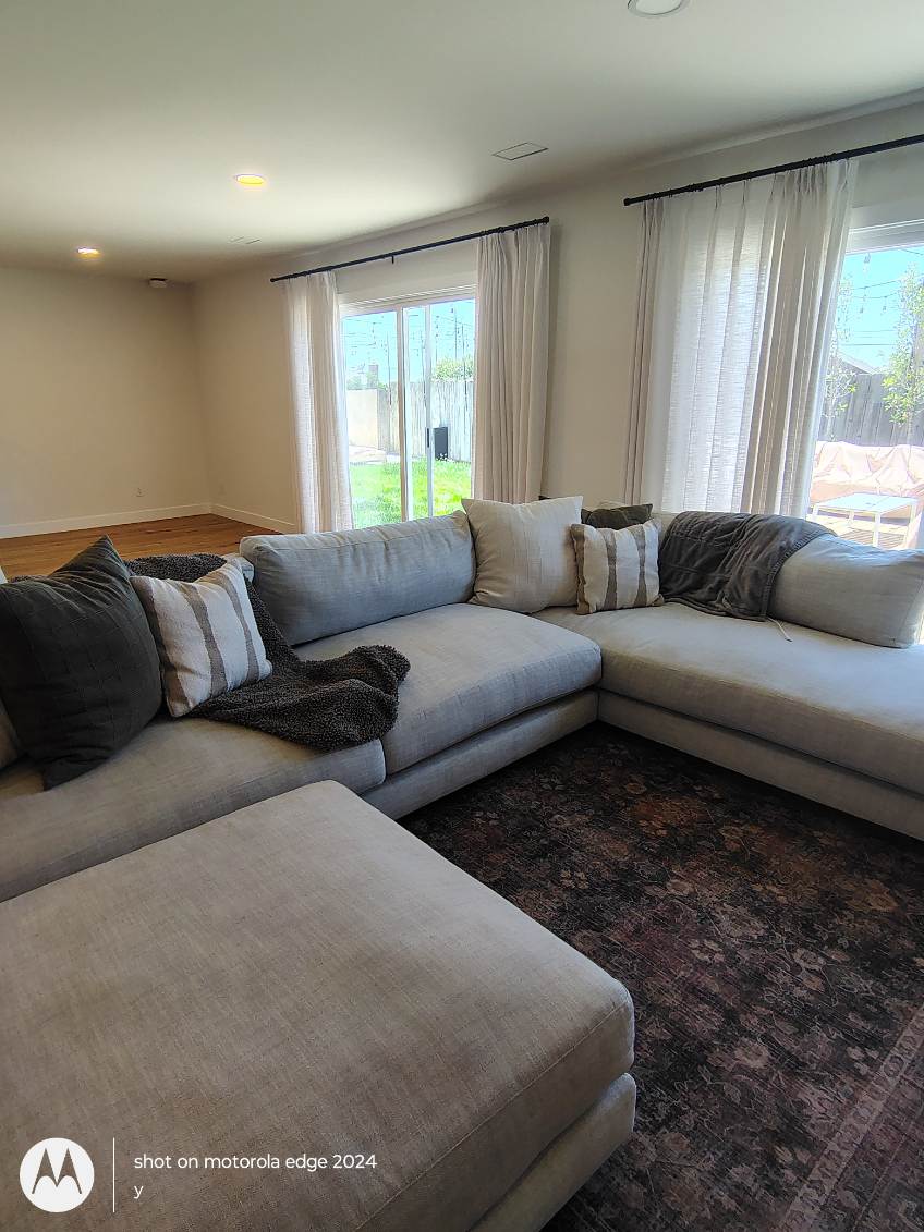 clean living room with gray sectional sofa after deep cleaning service