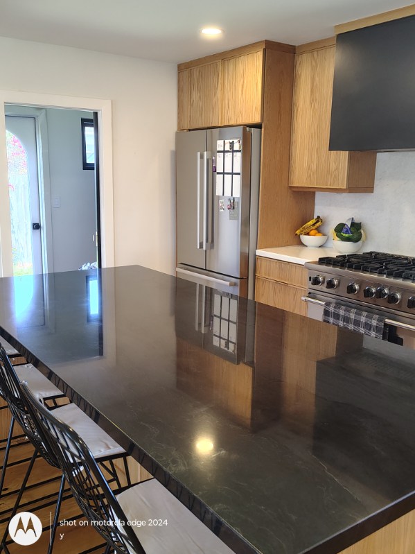 clean kitchen island with stainless steel refrigerator after deep cleaning